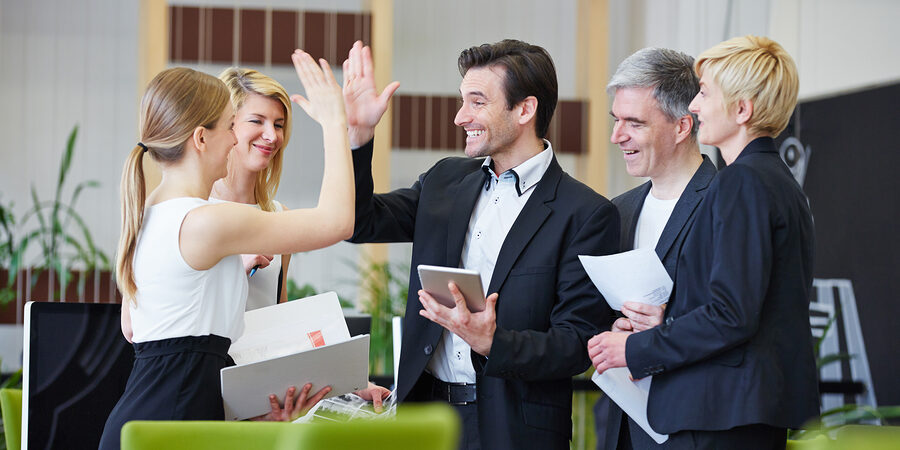 Successful team of business people giving high five in the office