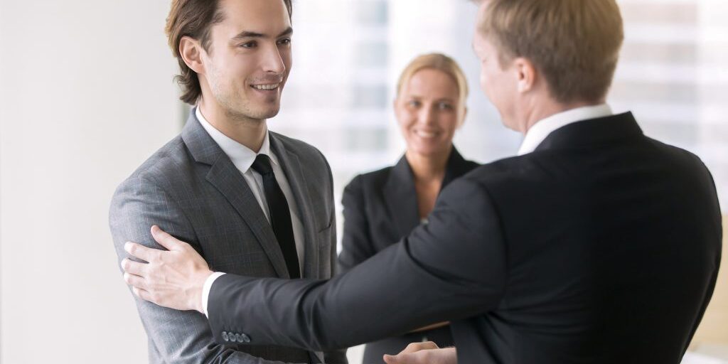 Boss promoting young subordinate. Two businessmen handshaking, congratulating on promotion, ensure long-term prosperity, human resource solutions, hired effective team, advancement of company position